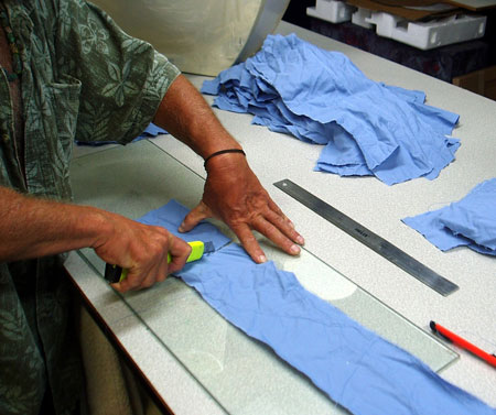 Cutting cloth strips into various sizes.
